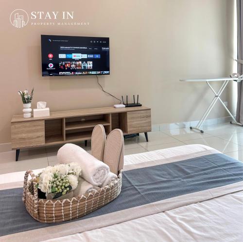 a room with a bed with a tv on the wall at Atria Sofo Suites - Petaling Jaya in Petaling Jaya