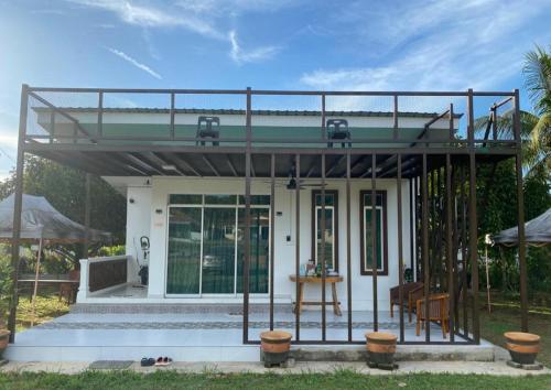 a small white house with a metal roof at HOMESTAY JERAI GEOPARK in Guar Chempedak