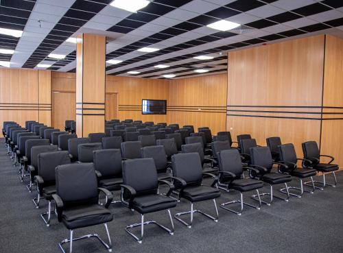 a conference room with black chairs and wooden walls at Waves Aqua Resort in Kenitra