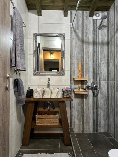 a bathroom with a sink and a mirror at Λευκό γιασεμί - Νέες Παγασές Βόλος in Kritharia