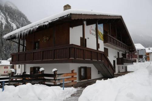 a large building with snow on the side of it at Arnica in Canazei