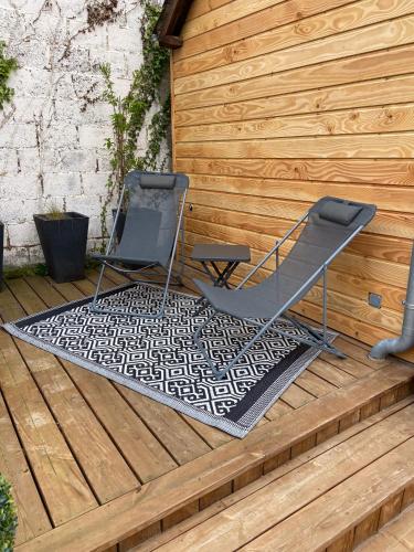 twee stoelen op een tapijt op een houten terras bij Le gîte 248 in Drucat