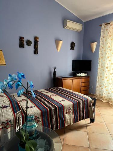 Villa Iris في إيغليسياس: غرفة نوم بسرير وطاولة وتلفزيون