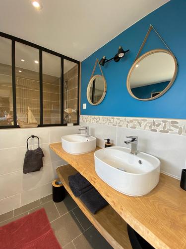 een badkamer met 2 wastafels en spiegels op een aanrecht bij Le gîte 248 in Drucat