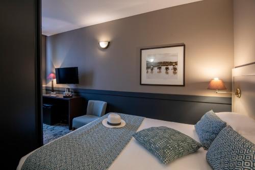 a hotel room with a bed and a chair and a desk at Best Western Plus Nice Cosy Hotel in Nice