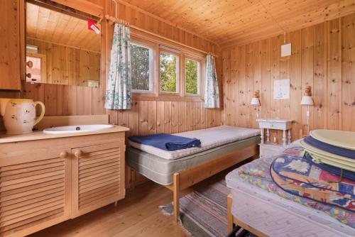 a room with two beds and a sink in a cabin at Cozy and unassuming cabin with fantastic views in Ørnes