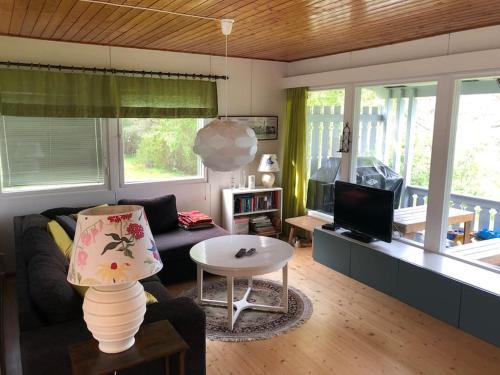sala de estar con sofá y mesa en Cottage with own beach, seaterrace & pavillion. en Mariehamn
