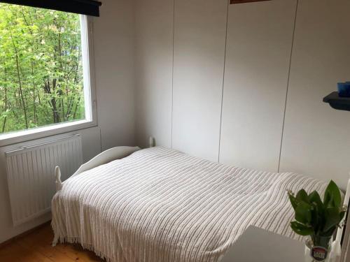 Habitación blanca con cama y ventana en Cottage with own beach, seaterrace & pavillion. en Mariehamn