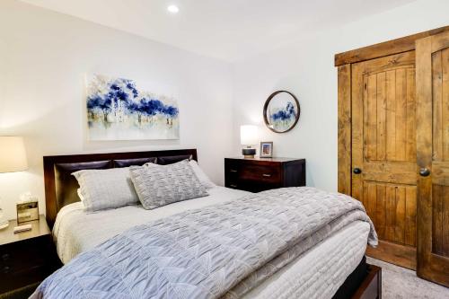 a bedroom with a bed and a wooden door at Elegant Vail Home - Walk to Booth Falls Trail in Vail