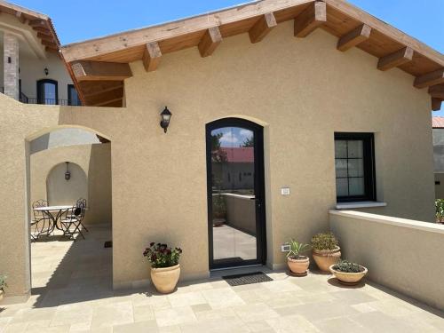 a house with a glass door and a patio at Highland Forest Zimmers in El-Rom