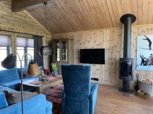 a living room with a blue couch and a stove at Hjemmekoselig hytte på Rauland in Rauland