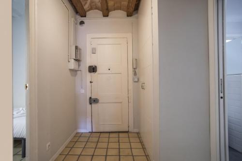a hallway with a white door and a tiled floor at 41COB1019- Charming rustic apartment in Barcelona