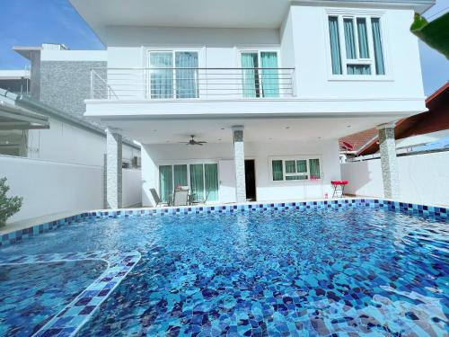 une maison avec une piscine en face d'une maison dans l'établissement Relax Pool Villa Near Walking Street,jacuzzi ,BBQ 5Bed 6Bath City house54, à Pattaya (sud)