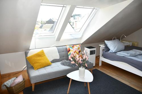 een woonkamer met een bank en een bed bij Modernes Studio in Richrath in Langenfeld
