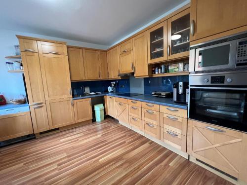 a large kitchen with wooden cabinets and wooden floors at Ferienzimmer zwischen Wien und Tulln in Tulln