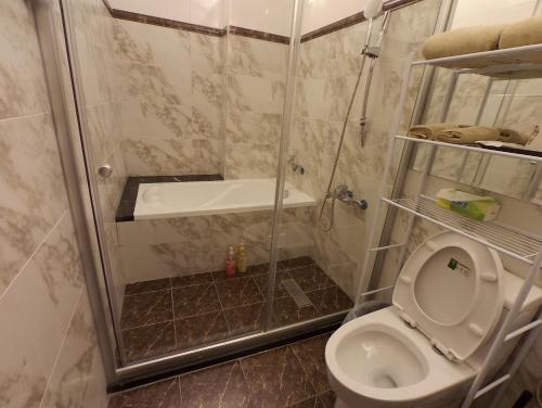 a bathroom with a shower and a toilet at B-wei B&B in Hualien City