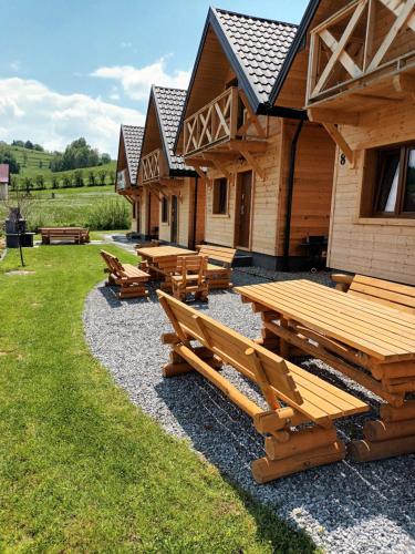 a group of picnic tables in front of a building at Motylowe Wzgórze Apartamenty Zawóz in Zawóz