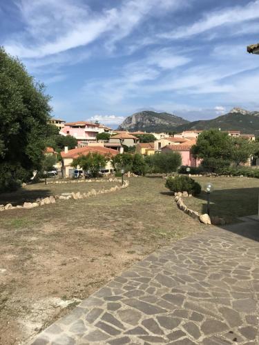 a cobblestone walkway leading to a town with houses at Villetta S'Arenada in Golfo Aranci