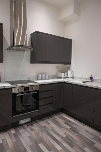 a kitchen with black cabinets and white counter tops at #20 Huge 2BR City Centre Apartment with Glass Ceiling Sleeps 6 Near Hull New Theatre in Hull