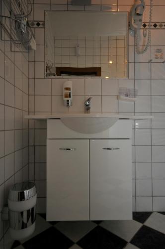 a white bathroom with a sink and a toilet at Pension Sonnenhof in Mörbisch am See