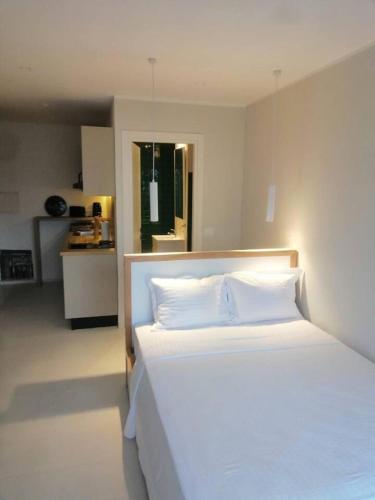- une chambre avec un grand lit blanc et des oreillers blancs dans l'établissement Charming and Luminous Studio in Lake 1 Tunis, à Tunis