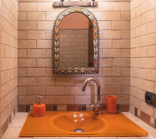 a bathroom sink with a mirror and orange candles at LAIZARRONDO in Arantza