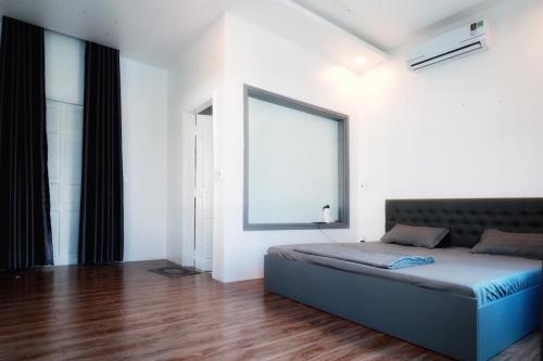 een slaapkamer met een bed en een groot raam bij Hồng Dương Villa Homestay - phòng đôi view sông Hương trung tâm thành phố #102 in Hue