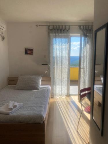 a bedroom with a bed and a large window at Villa Una Apartments in Labin