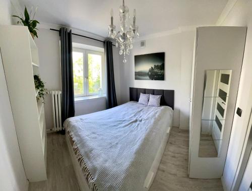 1 dormitorio con cama y lámpara de araña en Apartment Chambre Nowolipki, en Varsovia