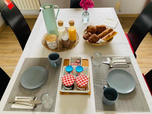 un tavolo con piatti e utensili e cibo sopra di Chez Maria a Pontorson