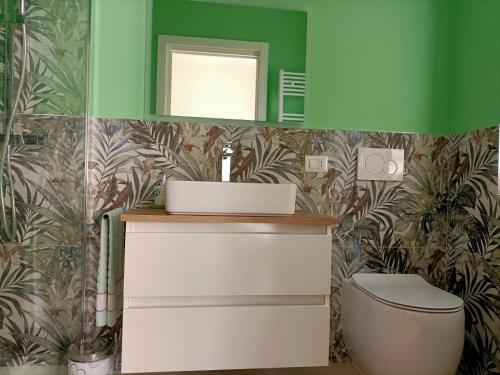 a bathroom with a toilet and a green wall at Nice days in Pescara