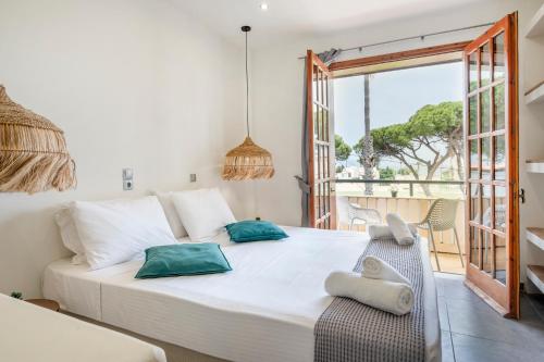 a bedroom with a large white bed and a balcony at Jonathan City Apartment in Kos Town