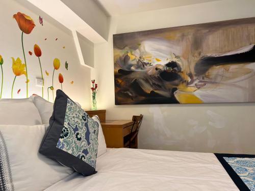a bedroom with a large painting on the wall at Tainan Canal Guest House in Anping