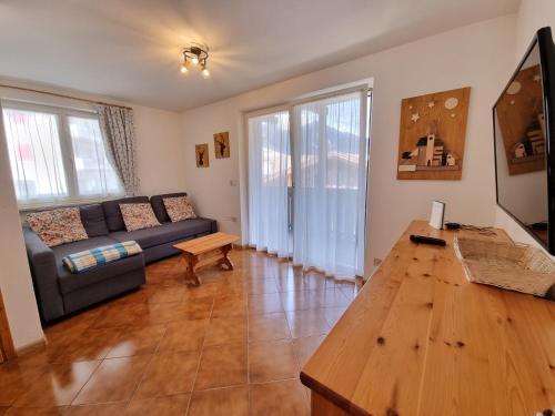 een woonkamer met een bank en een houten tafel bij Col Rodella in Campitello di Fassa