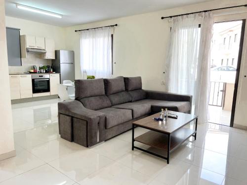 a living room with a couch and a coffee table at Paros 1 bedroom APT Kyklades in Paralimni