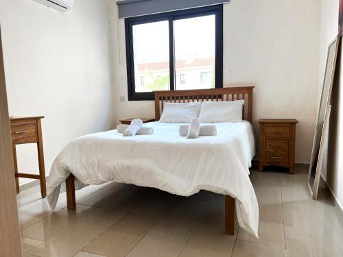 a bedroom with a bed with two pillows and a window at Paros 1 bedroom APT Kyklades in Paralimni
