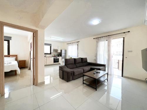 a living room with a couch and a table at Paros 1 bedroom APT Kyklades in Paralimni
