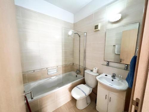 a bathroom with a tub and a toilet and a sink at Paros 1 bedroom APT Kyklades in Paralimni
