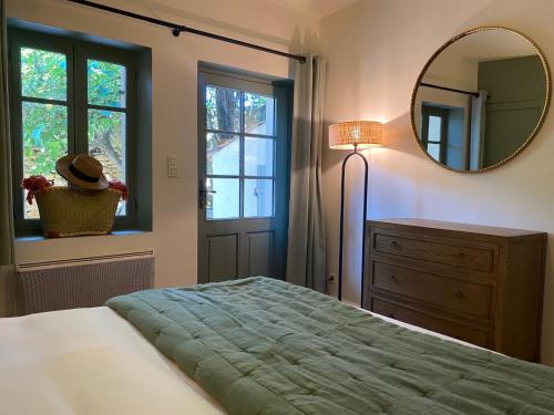 a bedroom with a bed and a mirror and a dresser at Domaine de Montine Chambres de Charme in Grignan