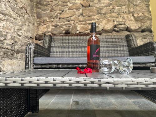 una botella de vino sentada en una mesa con copas en Agnanti Apartment en Kavala
