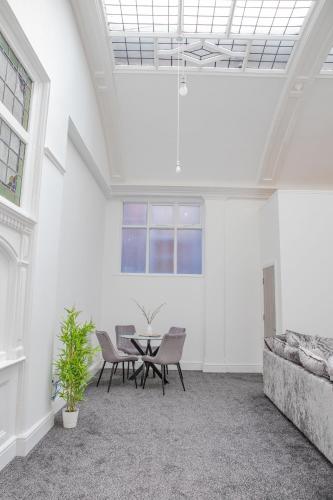 a white room with a table and chairs in it at #20 Huge 2BR City Centre Apartment with Glass Ceiling Sleeps 6 Near Hull New Theatre in Hull