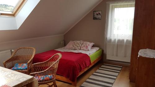 JaśliskaにあるOstoja w Lipowcuのベッドルーム1室(ベッド1台、椅子2脚、窓付)