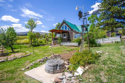 einen Hinterhof mit einer Feuerstelle und einem Haus in der Unterkunft Sunny Cedaredge Home with Mtn Views - Hike and Fish! in Cedaredge