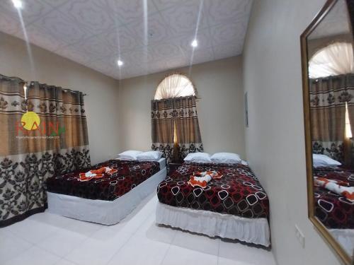 two beds in a room with two windows at kdk villa in Buccoo