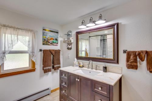 a bathroom with a sink and a mirror and a window at Sunny Cedaredge Home with Mtn Views - Hike and Fish! in Cedaredge