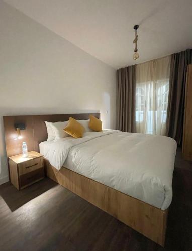 a bedroom with a large bed with white sheets and yellow pillows at Beach breeze in Essaouira