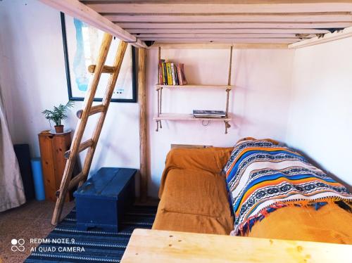 a couch in a room with a bunk bed at Cute Yellow house at the beach in Praia da Arrifana
