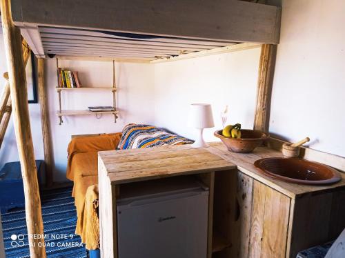 a tiny house with a sink and a couch at Cute Yellow house at the beach in Praia da Arrifana