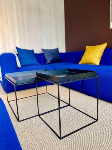 a blue couch with a glass coffee table in a living room at Matkráin Apartments in Hveragerði