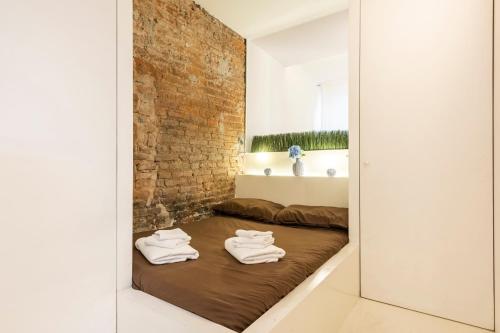 - une chambre avec un lit et des serviettes dans l'établissement Classe e Netflix in Piazza Vittoria Brescia, à Brescia